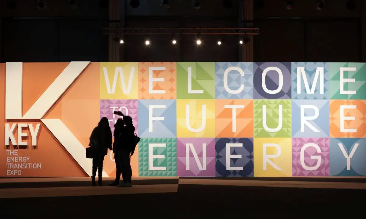 Persone silhouette davanti a un grande pannello colorato con la scritta "WELCOME TO FUTURE ENERGY" alla fiera Rimini Key Energy.