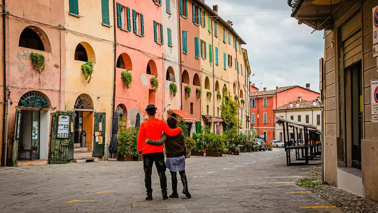 Coppia abbracciata in una strada con case colorate, un assaggio dei paesi belli vicino Ravenna.