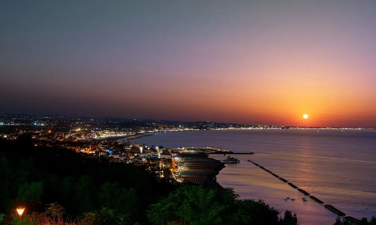 Tramonto su Gabicce Mare. Luci della città accese, un invito a scoprire cosa fare a Gabicce Mare la sera, tra passeggiate sul lungomare e cene vista mare.