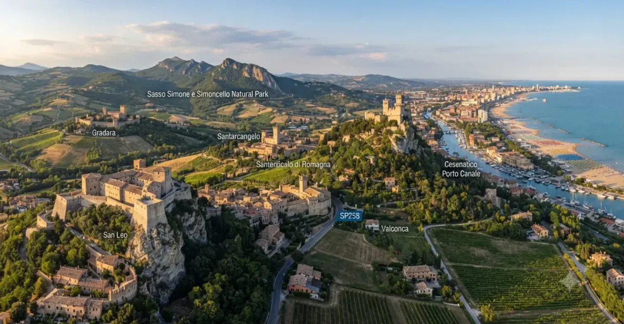 Panoramica aerea di borghi medievali e colline verdi, con il mare Adriatico sullo sfondo. Si vedono San Leo, Gradara, Santarcangelo e Cesenatico, un viaggio tra storia e natura in Romagna.