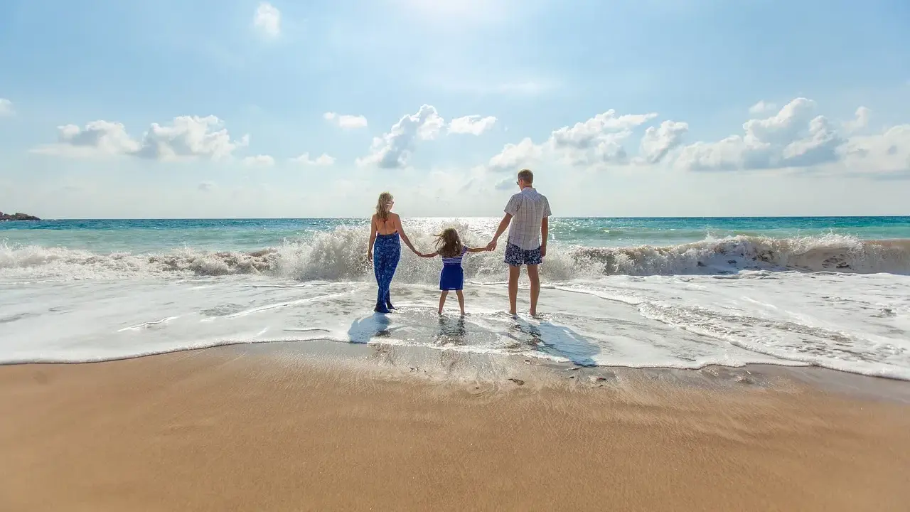 Famiglia felice sulla riviera romagnola con bambini, godendosi le onde del mare.