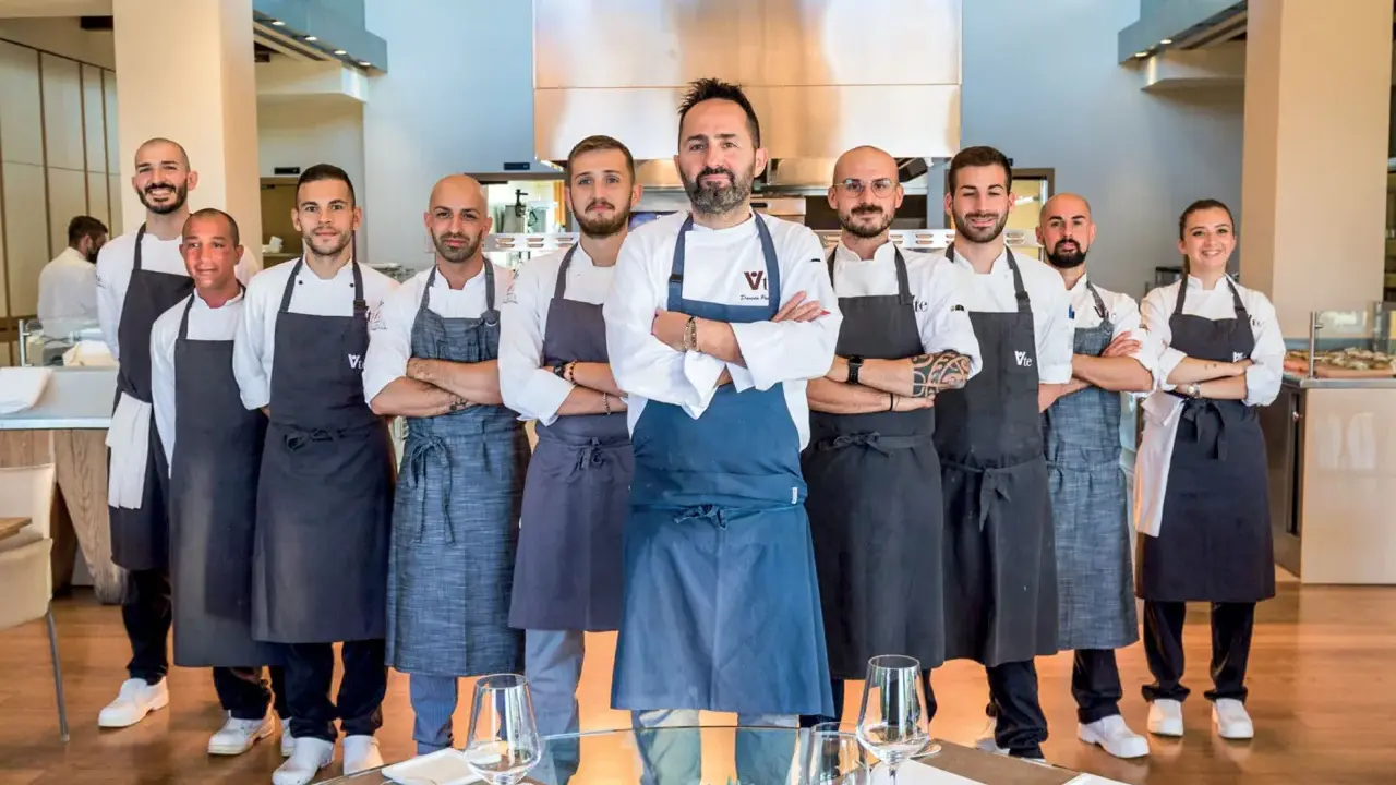 Il team di chef posa con orgoglio, pronto a servire esperienze culinarie d'eccellenza nei ristoranti stellati di Rimini.