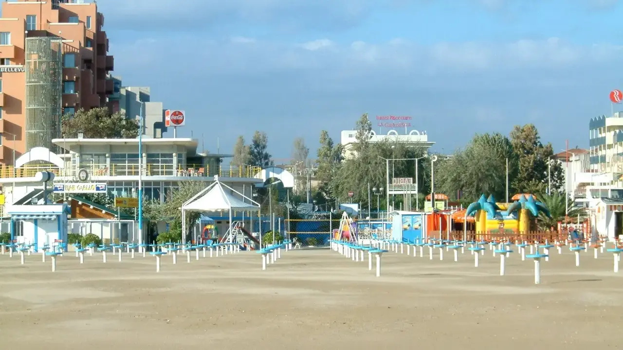Spiaggia di Rimini a settembre, con ombrelloni chiusi e giochi per bambini in attesa della prossima stagione.