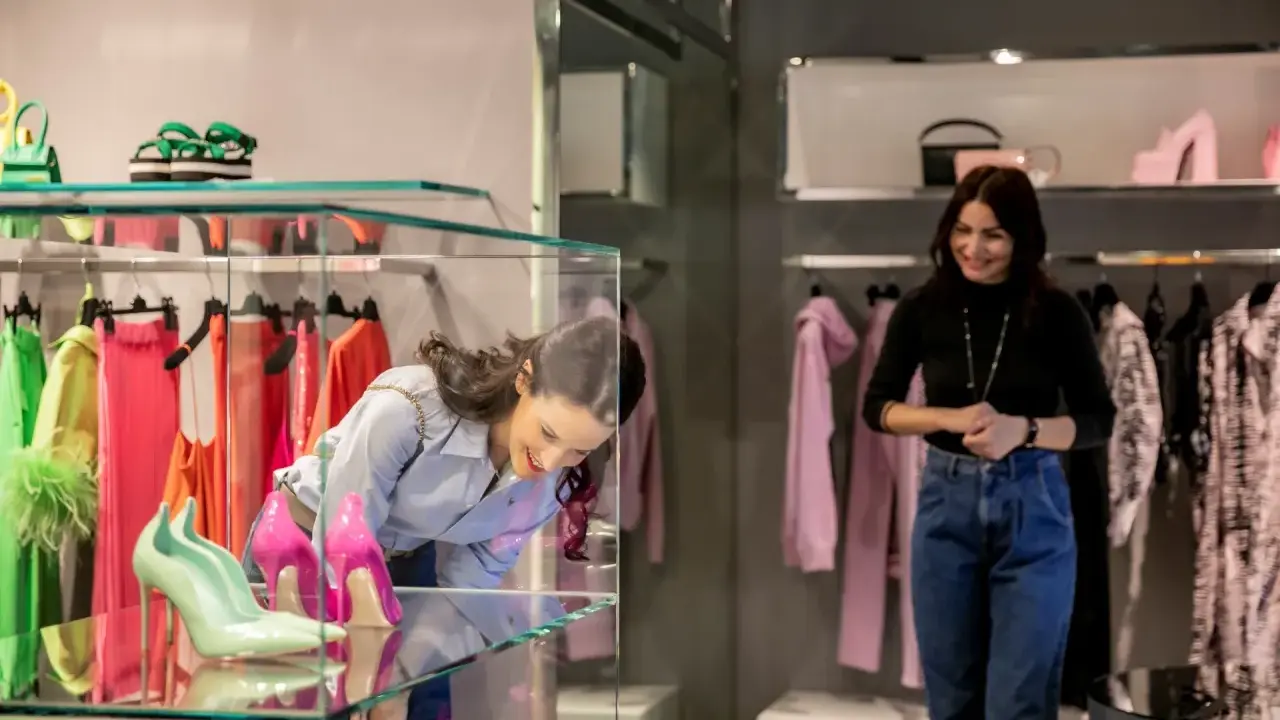Ragazza ammira scarpe in vetrina, tra i colorati negozi di Milano Marittima.