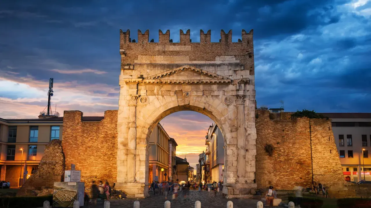 Arco d'Augusto a Rimini al tramonto, con il suo skyline suggestivo e le nuvole drammatiche.