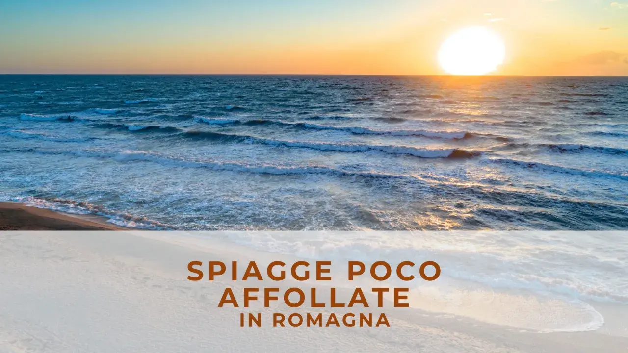 Tramonto su una spiaggia libera in Romagna, con onde che lambiscono la riva e il sole che illumina il mare.