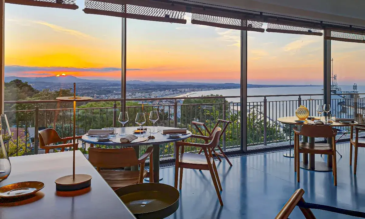 Tavoli apparecchiati in un ristorante con vista sul tramonto sul mare. Un'atmosfera magica per i ristoranti a Gabicce Monte.