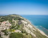 Panoramica aerea di Gabicce Mare, con case arroccate su una collina a picco sul mare Adriatico.
