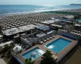 Vista aerea della spiaggia Le Palme Riccione con ombrelloni, piscine e cabine.