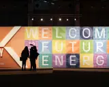 Persone silhouette davanti a un grande pannello colorato con la scritta "WELCOME TO FUTURE ENERGY" alla fiera Rimini Key Energy.