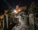 Sentiero lastricato di notte, illuminato da lampioni, conduce verso il castello di San Marino, il passo delle streghe.