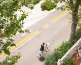 Una donna in bicicletta percorre il lungomare di San Mauro Mare, su una pista ciclabile ben segnalata.