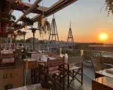 Tavoli apparecchiati in un ristorante con vista sul tramonto a Rimini. Un'atmosfera perfetta per gustare i sapori dei ristoranti romagnoli.