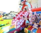 Bambini si divertono sulle giostre gonfiabili a Bellaria, scivolando e giocando in un parco acquatico pieno di allegria.