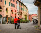 Coppia abbracciata in una strada con case colorate, un assaggio dei paesi belli vicino Ravenna.