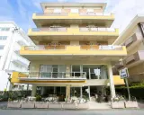 Hotel Ischia a Rimini Marebello, con le sue terrazze gialle e le finestre luminose, pronto ad accogliere i suoi ospiti per una vacanza al mare.