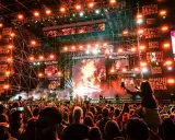 Folla in delirio al Rimini Beach Arena, luci psichedeliche e musica pulsante per un evento indimenticabile.