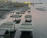 Lettini da spiaggia sommersi dall'acqua a Riccione, con la bassa marea che ha lasciato il segno.