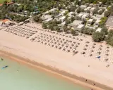 Domenica di sole sulla spiaggia di Rivazzurra, con ombrelloni, lettini e bagnanti che si godono il mare.