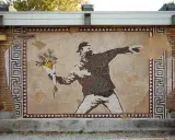IconosaiK project: street art a Ravenna con un mosaico che raffigura un uomo lancia fiori, un messaggio di pace.