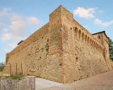 Antica fortezza nella valle del Rubicone, con mura in pietra e mattoni, torri e un loggiato ad archi.