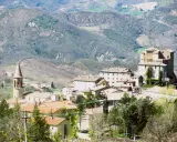 Borgo medievale con torre campanaria e rocca imponente, immerso tra le colline verdi. Un angolo di storia vicino a Marecchia Rimini.