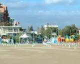 Spiaggia di Rimini a settembre, con ombrelloni chiusi e giochi per bambini in attesa della prossima stagione.