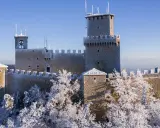 Le tre torri di San Marino innevate, un magico **percorso 3 torri San Marino** sotto un cielo azzurro.