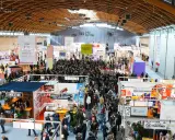 Folla in un padiglione fieristico, un'attrazione beer&food con stand e degustazioni.