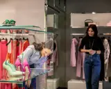 Ragazza ammira scarpe in vetrina, tra i colorati negozi di Milano Marittima.