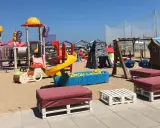 Area giochi per bambini sulla sabbia, con scivoli, altalene e piscina di palline. Un angolo di divertimento al Regina Beach Cattolica.