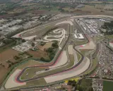 Vista aerea del circuito di Misano, noto anche come circuito San Marino, con tribune piene di spettatori e un vasto parcheggio.