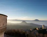 Panoramica di borghi vicino Riccione, con un antico torrione e colline nebbiose all'alba.