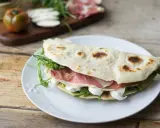 Piadina farcita con prosciutto crudo, mozzarella e rucola. Ecco come si farciscono le piadine per un pasto veloce e gustoso.