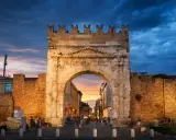Arco d'Augusto a Rimini al tramonto, con il suo skyline suggestivo e le nuvole drammatiche.