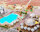 Vista aerea del lido delle sirene Cattolica: piscina, vasche idromassaggio, lettini rossi e ombrelloni sulla spiaggia.