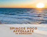 Tramonto su una spiaggia libera in Romagna, con onde che lambiscono la riva e il sole che illumina il mare.