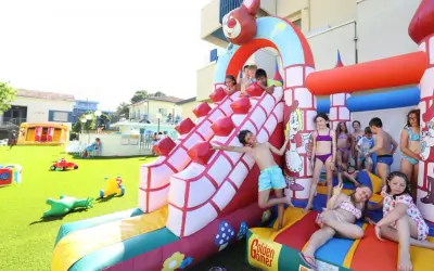 Bambini si divertono sulle giostre gonfiabili a Bellaria, scivolando e giocando in un parco acquatico pieno di allegria.