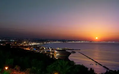 Tramonto su Gabicce Mare. Luci della città accese, un invito a scoprire cosa fare a Gabicce Mare la sera, tra passeggiate sul lungomare e cene vista mare.