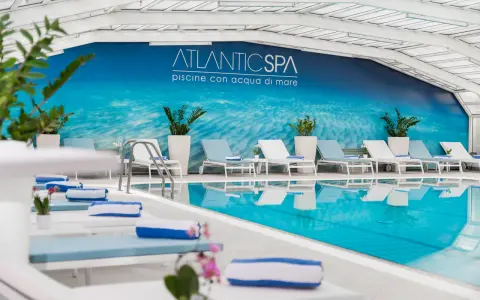Rilassati nei bagni Riccione con piscina, un'oasi di benessere con lettini e teli blu.