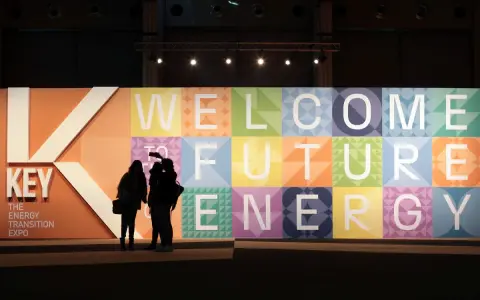 Persone silhouette davanti a un grande pannello colorato con la scritta "WELCOME TO FUTURE ENERGY" alla fiera Rimini Key Energy.