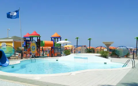 Piscina con scivolo e giochi acquatici in una giornata di sole a Cattolica, Emilia Romagna.