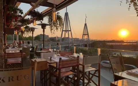Tavoli apparecchiati in un ristorante con vista sul tramonto a Rimini. Un'atmosfera perfetta per gustare i sapori dei ristoranti romagnoli.