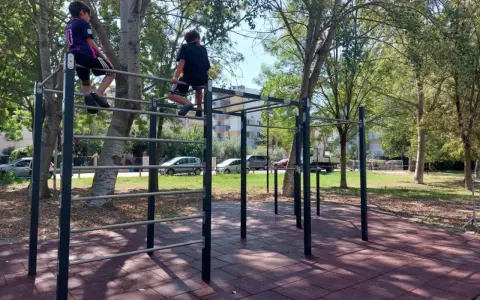 Bambini si arrampicano su una struttura per esercizi all'aperto nel parco Briolini a Rimini.