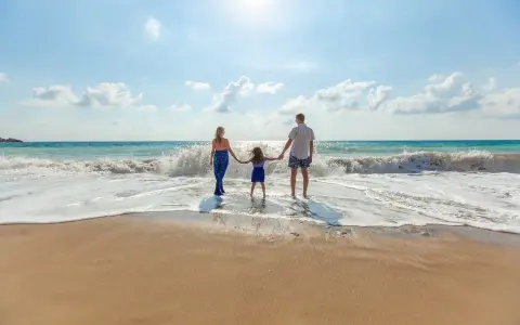 Famiglia felice sulla riviera romagnola con bambini, godendosi le onde del mare.