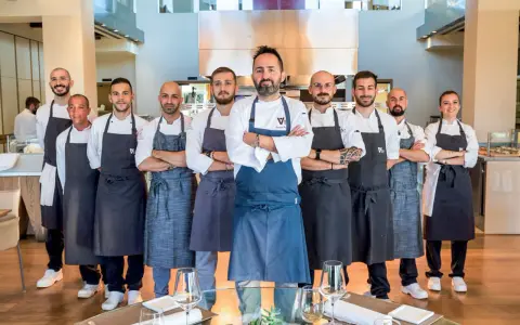 Il team di chef posa con orgoglio, pronto a servire esperienze culinarie d'eccellenza nei ristoranti stellati di Rimini.