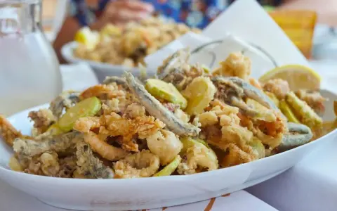 Fritto misto di pesce e verdure, un'ottima idea per cosa mangiare a Riccione. Croccante e saporito, perfetto con una caraffa di vino bianco.