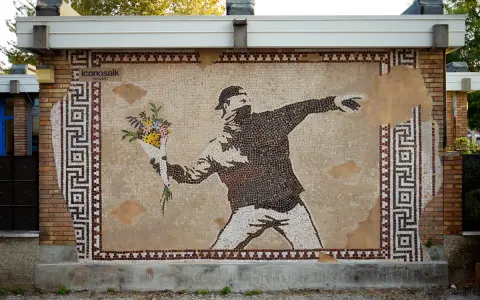 IconosaiK project: street art a Ravenna con un mosaico che raffigura un uomo lancia fiori, un messaggio di pace.