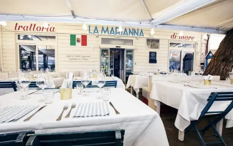 Tavoli apparecchiati per un pranzo all'aperto in uno dei ristoranti Rimini sul mare, "La Marianna".