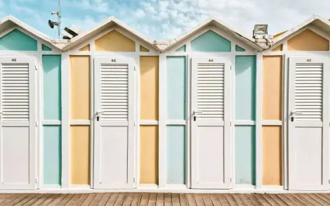 Cabine colorate sulla spiaggia, perfette per scoprire cosa fare a Riccione. Un'estate di sole e divertimento ti aspetta!